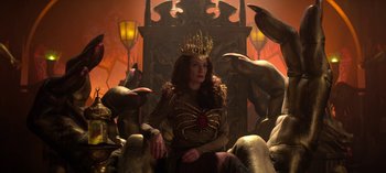 Movie still from “Chilling Adventures of Sabrina” (2018), created by Roberto Aguirre-Sacasa – A woman sitting on a throne surrounded by statues; Medium shot, Low angle