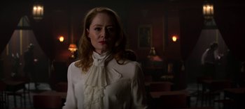 Movie still from “Chilling Adventures of Sabrina” (2018), created by Roberto Aguirre-Sacasa – A woman wearing a white shirt and a white bow tie; Medium shot, Over the shoulder angle