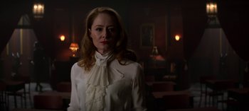 Movie still from “Chilling Adventures of Sabrina” (2018), created by Roberto Aguirre-Sacasa – A woman wearing a white shirt and a white bow tie; Medium shot, Over the shoulder angle