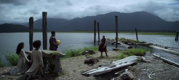 Movie still from “Chilling Adventures of Sabrina” (2018), created by Roberto Aguirre-Sacasa – Two people standing on the shore of a body of water; Extreme Wide shot, Over the shoulder angle