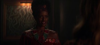 Movie still from “Chilling Adventures of Sabrina” (2018), created by Roberto Aguirre-Sacasa – A woman in a red dress and a head scarf; Close Up shot, Over the shoulder angle