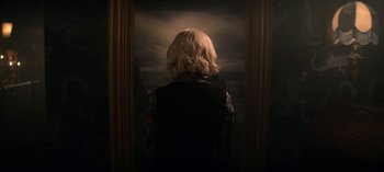 Movie still from “Chilling Adventures of Sabrina” (2018), created by Roberto Aguirre-Sacasa – A woman standing in front of a window looking out at the ocean; Medium shot, Overhead angle