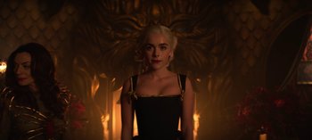 Movie still from “Chilling Adventures of Sabrina” (2018), created by Roberto Aguirre-Sacasa – A woman with blonde hair standing in front of a wall; Medium shot, Low angle
