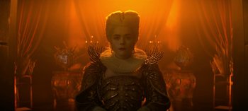 Movie still from “Chilling Adventures of Sabrina” (2018), created by Roberto Aguirre-Sacasa – A woman dressed in a gold costume and a yellow wig; Medium shot, Low angle