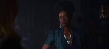 Movie still from “Chilling Adventures of Sabrina” (2018), created by Roberto Aguirre-Sacasa – A black woman with a large afro is posing for a picture; Close Up shot, Low angle
