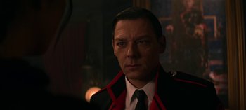 Movie still from “Chilling Adventures of Sabrina” (2018), created by Roberto Aguirre-Sacasa – A person wearing a suit and tie; Close Up shot, Over the shoulder angle