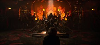 Movie still from “Chilling Adventures of Sabrina” (2018), created by Roberto Aguirre-Sacasa – A woman standing in front of an illuminated stage; Extreme Wide shot, High angle