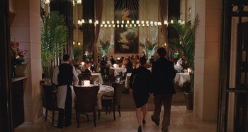 Movie still from “Chloe” (2009), directed by Atom Egoyan – People are dining in a large restaurant with many tables and chairs; Wide shot, Over the shoulder angle