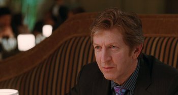 Movie still from “Chloe” (2009), directed by Atom Egoyan – A person wearing a suit and tie; Close Up shot, Over the shoulder angle