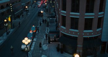 Movie still from “Chloe” (2009), directed by Atom Egoyan – A street view of a city at night with cars parked on the side of the street; Extreme Wide shot, High angle