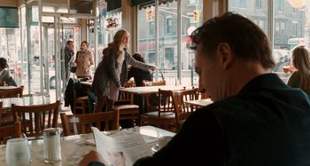 Movie still from “Chloe” (2009), directed by Atom Egoyan – A man sitting at a table in front of a woman; Medium shot, Over the shoulder angle