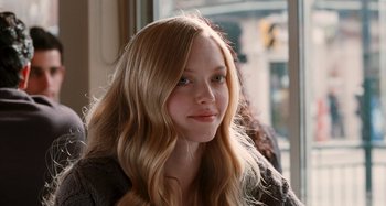 Movie still from “Chloe” (2009), directed by Atom Egoyan – A girl with long blonde hair sitting in front of a window; Close Up shot, Over the shoulder angle
