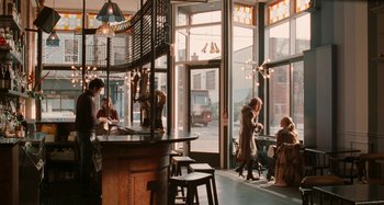 Movie still from “Chloe” (2009), directed by Atom Egoyan – People are sitting at tables in a restaurant; Wide shot, Over the shoulder angle