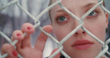 Movie still from “Chloe” (2009), directed by Atom Egoyan – A person's face behind a chain link fence; Close Up shot, Overhead angle