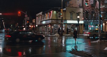 Movie still from “Chloe” (2009), directed by Atom Egoyan – A woman crossing a street at night in the rain; Extreme Wide shot, High angle