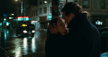 Movie still from “Chloe” (2009), directed by Atom Egoyan – A man and a woman hugging on a city street; Close Up shot, Low angle