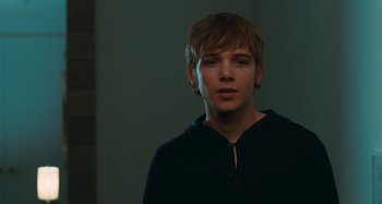Movie still from “Chloe” (2009), directed by Atom Egoyan – A young man in a black shirt is looking at the camera; Close Up shot, Over the shoulder angle