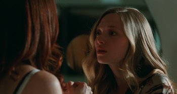 Movie still from “Chloe” (2009), directed by Atom Egoyan – A woman looking at her reflection in a mirror; Close Up shot, Over the shoulder angle