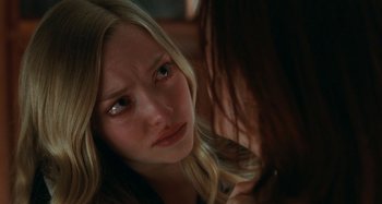Movie still from “Chloe” (2009), directed by Atom Egoyan – A young girl with long blonde hair looking at the camera; Close Up shot, Over the shoulder angle