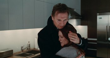 Movie still from “Chloe” (2009), directed by Atom Egoyan – A man and a woman in a kitchen hugging each other; Medium shot, Low angle