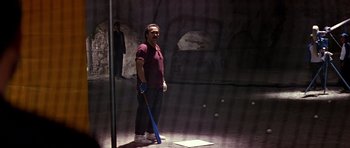 Movie still from “Clear and Present Danger” (1994), directed by Phillip Noyce – A man holding a baseball bat while standing next to a pole; Wide shot, High angle