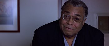 Movie still from “Clear and Present Danger” (1994), directed by Phillip Noyce – An older man wearing glasses and a suit; Close Up shot, Over the shoulder angle