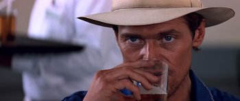 Movie still from “Clear and Present Danger” (1994), directed by Phillip Noyce – A person holding a glass of water; Extreme Close Up shot, Over the shoulder angle