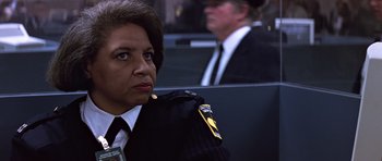 Movie still from “Clear and Present Danger” (1994), directed by Phillip Noyce – A woman in a uniform sitting next to a man in a suit and tie; Close Up shot, Low angle