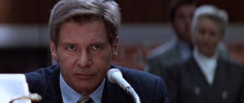 Movie still from “Clear and Present Danger” (1994), directed by Phillip Noyce – A person wearing a suit and tie; Close Up shot, Over the shoulder angle