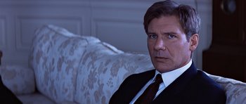 Movie still from “Clear and Present Danger” (1994), directed by Phillip Noyce – A person wearing a suit and tie; Close Up shot, Low angle