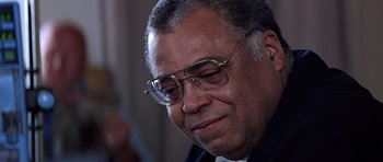 Movie still from “Clear and Present Danger” (1994), directed by Phillip Noyce – An older man wearing glasses looking down at his face; Close Up shot, Over the shoulder angle