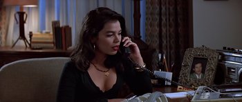 Movie still from “Clear and Present Danger” (1994), directed by Phillip Noyce – A woman sitting at a table talking on the phone; Close Up shot, High angle