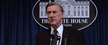 Movie still from “Clear and Present Danger” (1994), directed by Phillip Noyce – A man standing in front of microphones in front of the white house; Close Up shot, Low angle