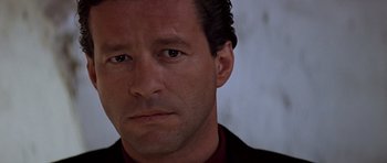 Movie still from “Clear and Present Danger” (1994), directed by Phillip Noyce – A person wearing a suit and tie; Close Up shot, Low angle