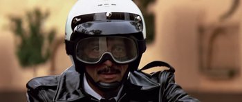 Movie still from “Clear and Present Danger” (1994), directed by Phillip Noyce – A man wearing a motorcycle helmet and a leather jacket; Close Up shot, Low angle