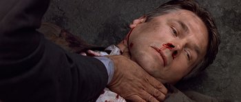 Movie still from “Clear and Present Danger” (1994), directed by Phillip Noyce – A man with blood all over his face and neck; Close Up shot, Overhead angle