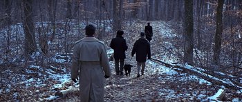Movie still from “Clear and Present Danger” (1994), directed by Phillip Noyce – A group of people walking down a path in the woods; Wide shot, High angle