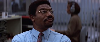 Movie still from “Clear and Present Danger” (1994), directed by Phillip Noyce – A man in a blue shirt wearing glasses and a red tie; Close Up shot, Low angle