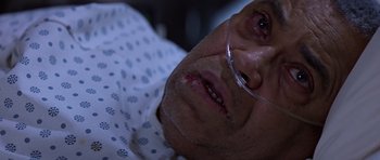 Movie still from “Clear and Present Danger” (1994), directed by Phillip Noyce – An older man wearing glasses is laying in a bed; Close Up shot, Overhead angle