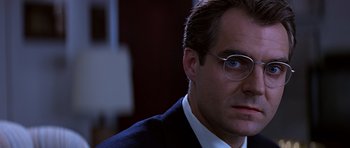 Movie still from “Clear and Present Danger” (1994), directed by Phillip Noyce – A person wearing glasses and a suit; Close Up shot, Low angle