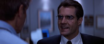 Movie still from “Clear and Present Danger” (1994), directed by Phillip Noyce – A person wearing a suit and glasses; Close Up shot, Low angle