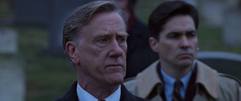Movie still from “Clear and Present Danger” (1994), directed by Phillip Noyce – A person wearing a suit and tie; Close Up shot, Over the shoulder angle