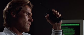Movie still from “Clear and Present Danger” (1994), directed by Phillip Noyce – A person holding a walkie talkie; Close Up shot, Low angle