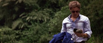 Movie still from “Clear and Present Danger” (1994), directed by Phillip Noyce – A man in a blue shirt is holding a blue jacket; Medium shot, Low angle