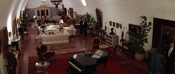 Movie still from “Clear and Present Danger” (1994), directed by Phillip Noyce – Two people in a living room with a piano; Extreme Wide shot, High angle