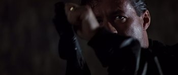 Movie still from “Clear and Present Danger” (1994), directed by Phillip Noyce – A man holding a gun in a dark room; Close Up shot, Low angle