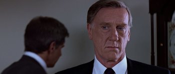 Movie still from “Clear and Present Danger” (1994), directed by Phillip Noyce – A man in a suit and tie looking at another man in a suit and tie; Close Up shot, Over the shoulder angle