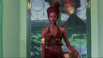 Movie still from “Coming to America” (1988), directed by John Landis – A woman wearing a head scarf and holding an object in her hand; Medium shot, Low angle