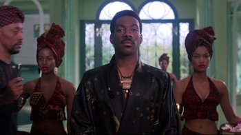Movie still from “Coming to America” (1988), directed by John Landis – A man standing in front of a group of women; Medium shot, Low angle