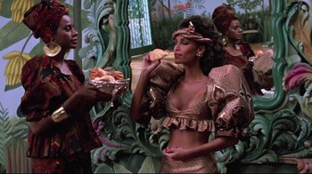 Movie still from “Coming to America” (1988), directed by John Landis – A group of women standing next to each other holding food; Medium shot, Over the shoulder angle